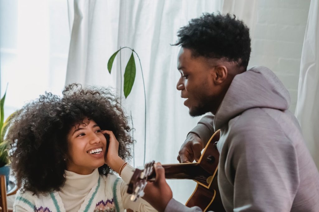 black man playing guitar for girlfriend